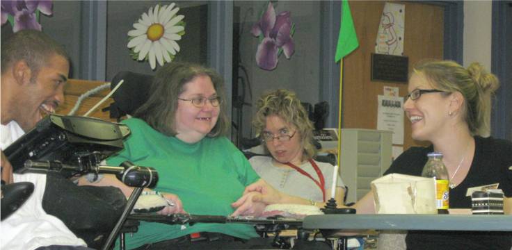 Three residents and a staff member play trivia in therapeutic recreation