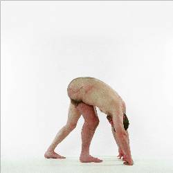 Side view of naked man in triangle position. One leg is cut away and moved hehind the other.