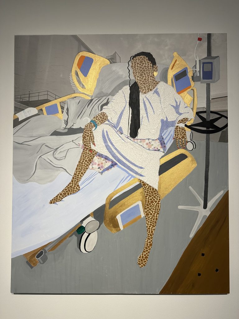 Between Drips and Dignity (2026). Acrylic, paper, vellum photograph, glass. 72 x 60 inches. Image Description: A faceless woman with giraffe patterned skin dressed in a white hospital gown sits upright in a gold embellished hospital bed with one foot dangling to the floor. Her long black hair is pulled to the side to reveal a prominent gold heart earring. Her bright red nail polish stands out as prominent as her hospital band. On the right is an IV and monitor stand. Three tiny square mirrors sit on top of a brown painted lower right corner. Artwork photographed by Chanika Svetvilas. Image reproduced in Wordgathering with permission of the original artist, Jazlyne Sabree, and the photographer of the work, Chanika Svetvilas.